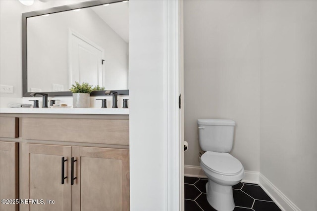 bathroom featuring tile patterned flooring, toilet, vanity, and baseboards