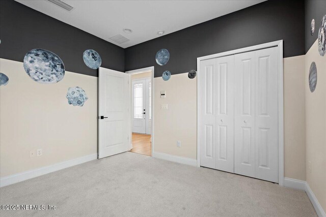 unfurnished bedroom featuring a closet, baseboards, and carpet