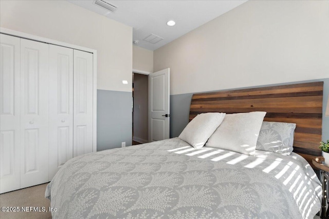 bedroom with a closet, visible vents, and recessed lighting