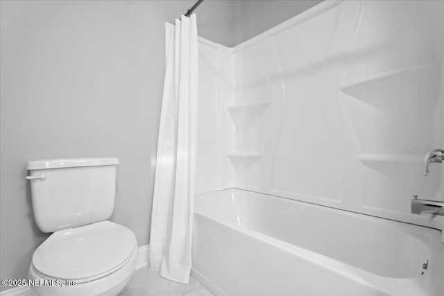 full bath featuring tile patterned floors, toilet, and shower / bath combo with shower curtain