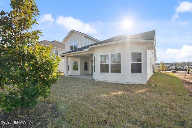 rear view of property with a yard and a patio