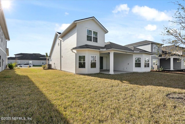 rear view of house with a yard, central air condition unit, and a patio area