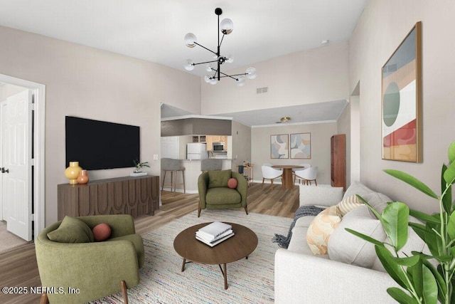 living area featuring visible vents, a high ceiling, an inviting chandelier, and wood finished floors