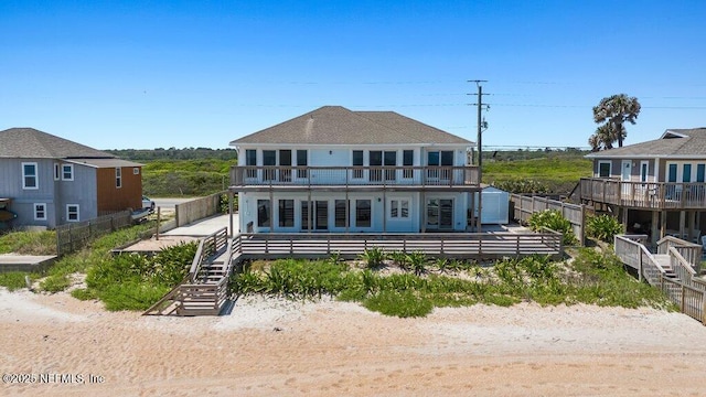 rear view of house with stairs and a balcony