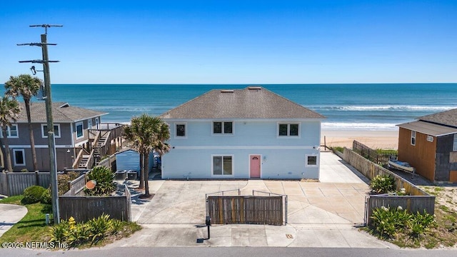 exterior space with a beach view and fence private yard