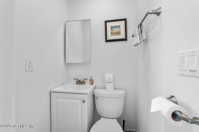 half bath featuring toilet and vanity