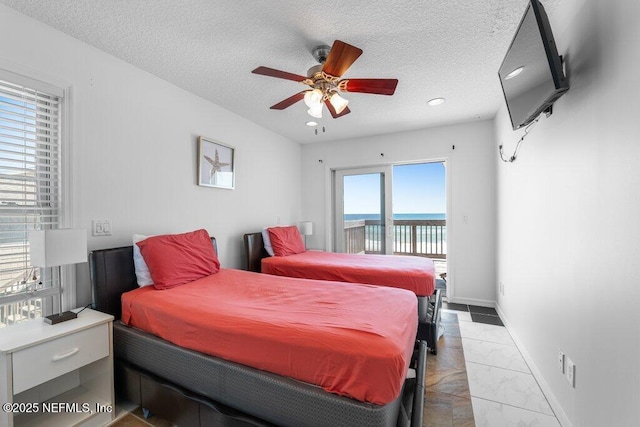 bedroom featuring recessed lighting, a water view, baseboards, a textured ceiling, and access to outside