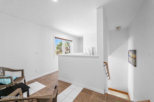 interior space with tile patterned flooring, baseboards, and an upstairs landing
