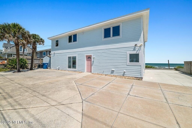back of house with a patio area and a water view