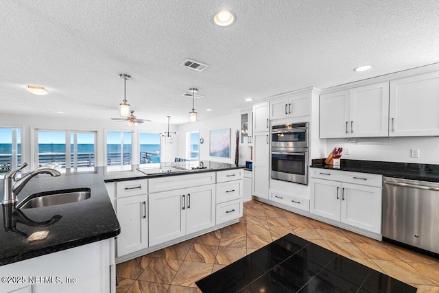 kitchen with stainless steel appliances, visible vents, a sink, and a wealth of natural light