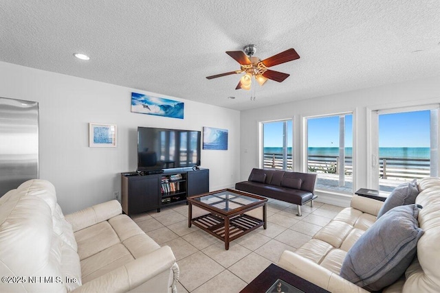 living area featuring a ceiling fan, a textured ceiling, recessed lighting, and light tile patterned floors