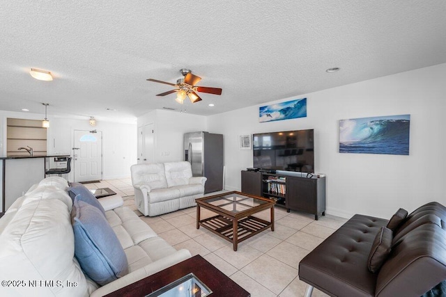living room featuring a ceiling fan, a textured ceiling, and light tile patterned flooring