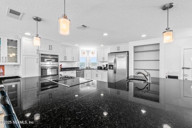 kitchen featuring stainless steel appliances, a textured ceiling, and a sink