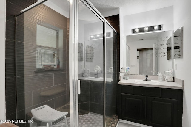 full bathroom with a shower stall and vanity