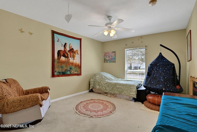 carpeted bedroom featuring baseboards, a textured ceiling, and ceiling fan