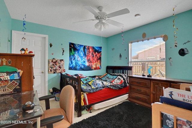 carpeted bedroom with a textured ceiling and a ceiling fan