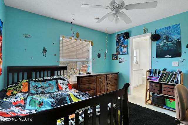 carpeted bedroom with ceiling fan, a textured ceiling, and ensuite bath