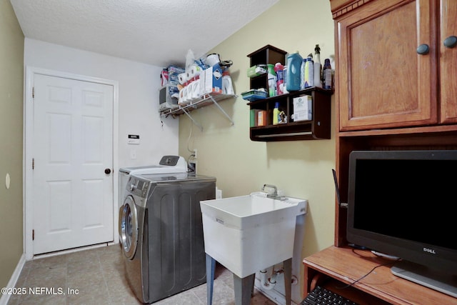 washroom featuring a sink, a textured ceiling, independent washer and dryer, and light tile patterned floors