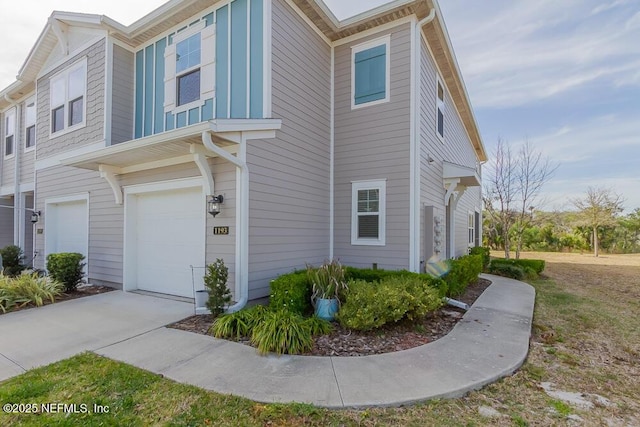 view of property exterior with an attached garage and driveway