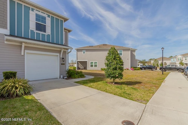 view of front facade with concrete driveway, a garage, board and batten siding, and a front lawn