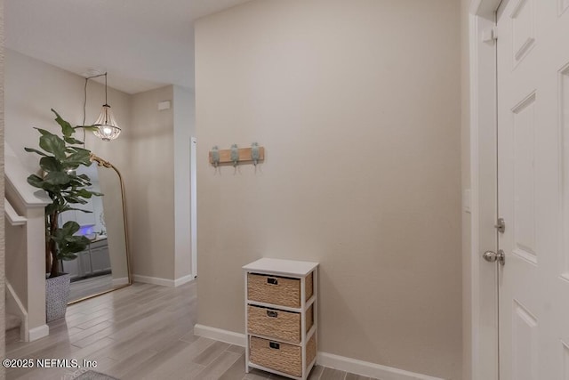 hallway featuring baseboards and light wood-style floors