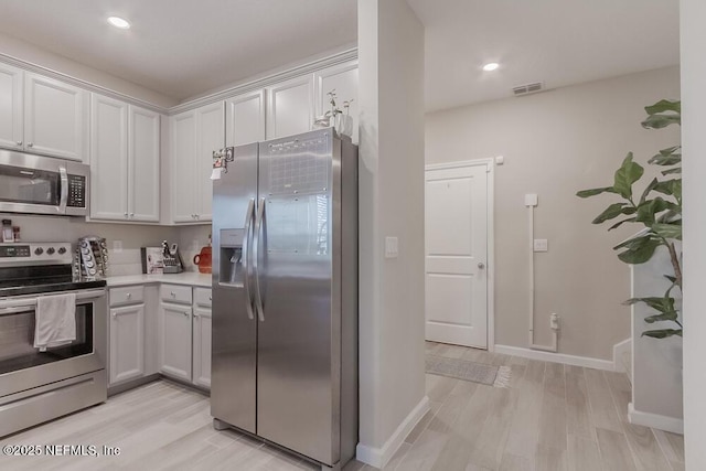 kitchen featuring visible vents, light wood finished floors, appliances with stainless steel finishes, and light countertops