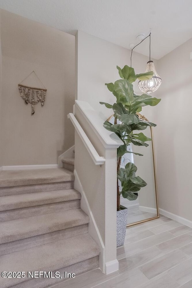 staircase with wood finished floors and baseboards