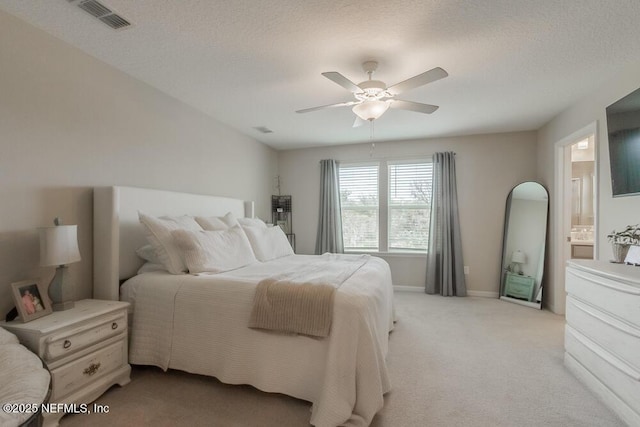 bedroom with visible vents, baseboards, light colored carpet, a textured ceiling, and a ceiling fan