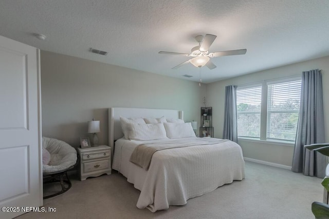 bedroom featuring carpet flooring, a ceiling fan, visible vents, and a textured ceiling