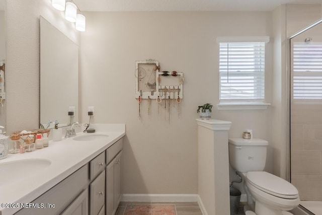 bathroom with double vanity, a stall shower, toilet, and a sink