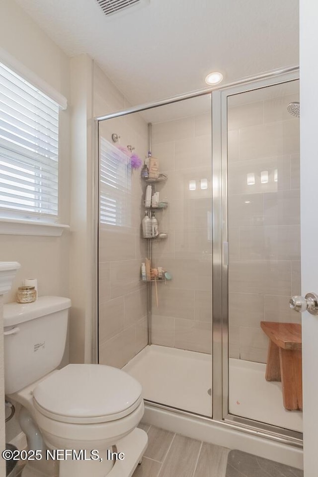 full bathroom with visible vents, toilet, and a shower stall