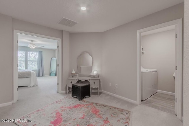 bedroom with carpet, washing machine and dryer, visible vents, and baseboards