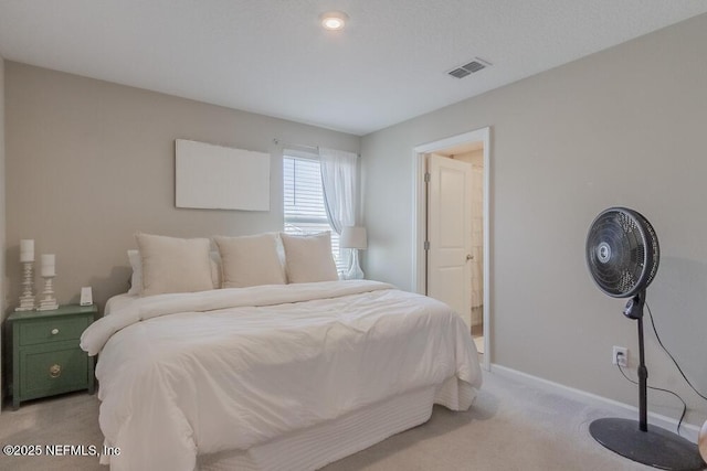 bedroom with visible vents, light carpet, and baseboards