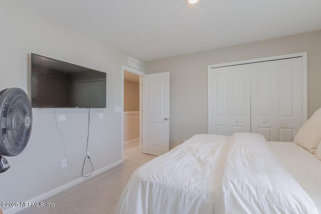 carpeted bedroom featuring a closet, baseboards, and visible vents