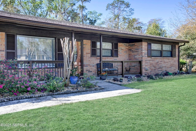 ranch-style home featuring brick siding, a porch, and a front lawn