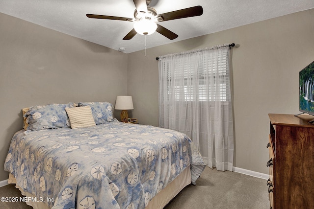 carpeted bedroom with a ceiling fan, baseboards, and a textured ceiling