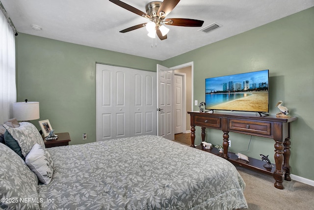 carpeted bedroom with visible vents, baseboards, a closet, and a ceiling fan