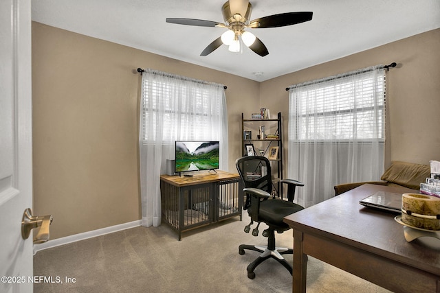 carpeted office with baseboards and ceiling fan