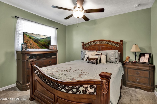 bedroom with a textured ceiling, baseboards, carpet, and a ceiling fan