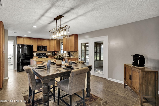 dining room with recessed lighting, a textured ceiling, and baseboards