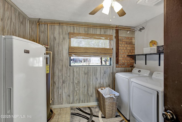 laundry area featuring wood walls, laundry area, washer and dryer, a textured ceiling, and a ceiling fan