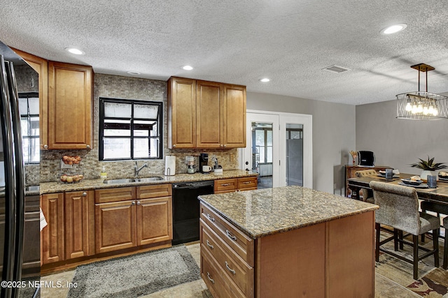 kitchen featuring a wealth of natural light, visible vents, black appliances, and a sink