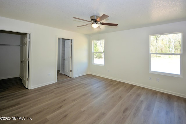 unfurnished bedroom with wood finished floors, baseboards, and a textured ceiling