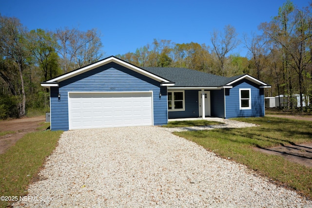 ranch-style house featuring a front yard, an attached garage, and driveway