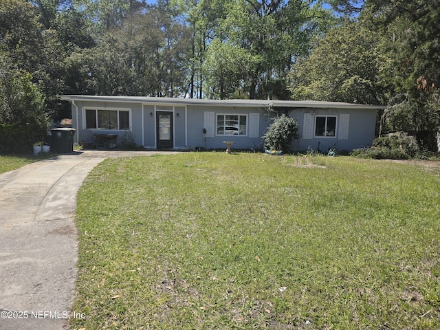 single story home with concrete driveway and a front yard