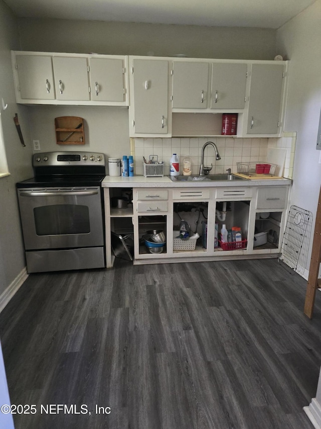 kitchen with decorative backsplash, a sink, dark wood finished floors, light countertops, and stainless steel electric range oven