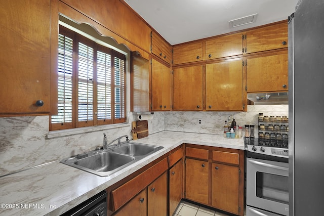 kitchen featuring visible vents, a sink, extractor fan, light countertops, and tasteful backsplash