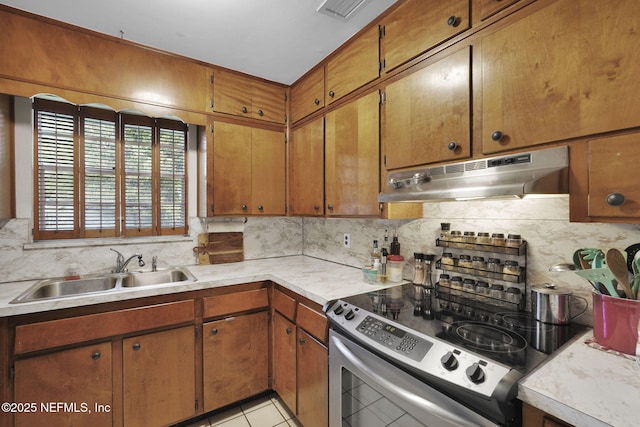 kitchen featuring backsplash, under cabinet range hood, stainless steel electric stove, light countertops, and a sink