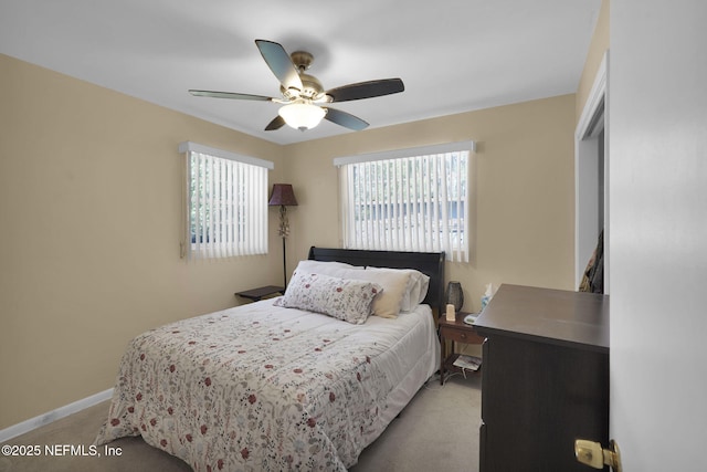 bedroom featuring light carpet, ceiling fan, and baseboards