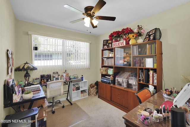 carpeted home office with a ceiling fan